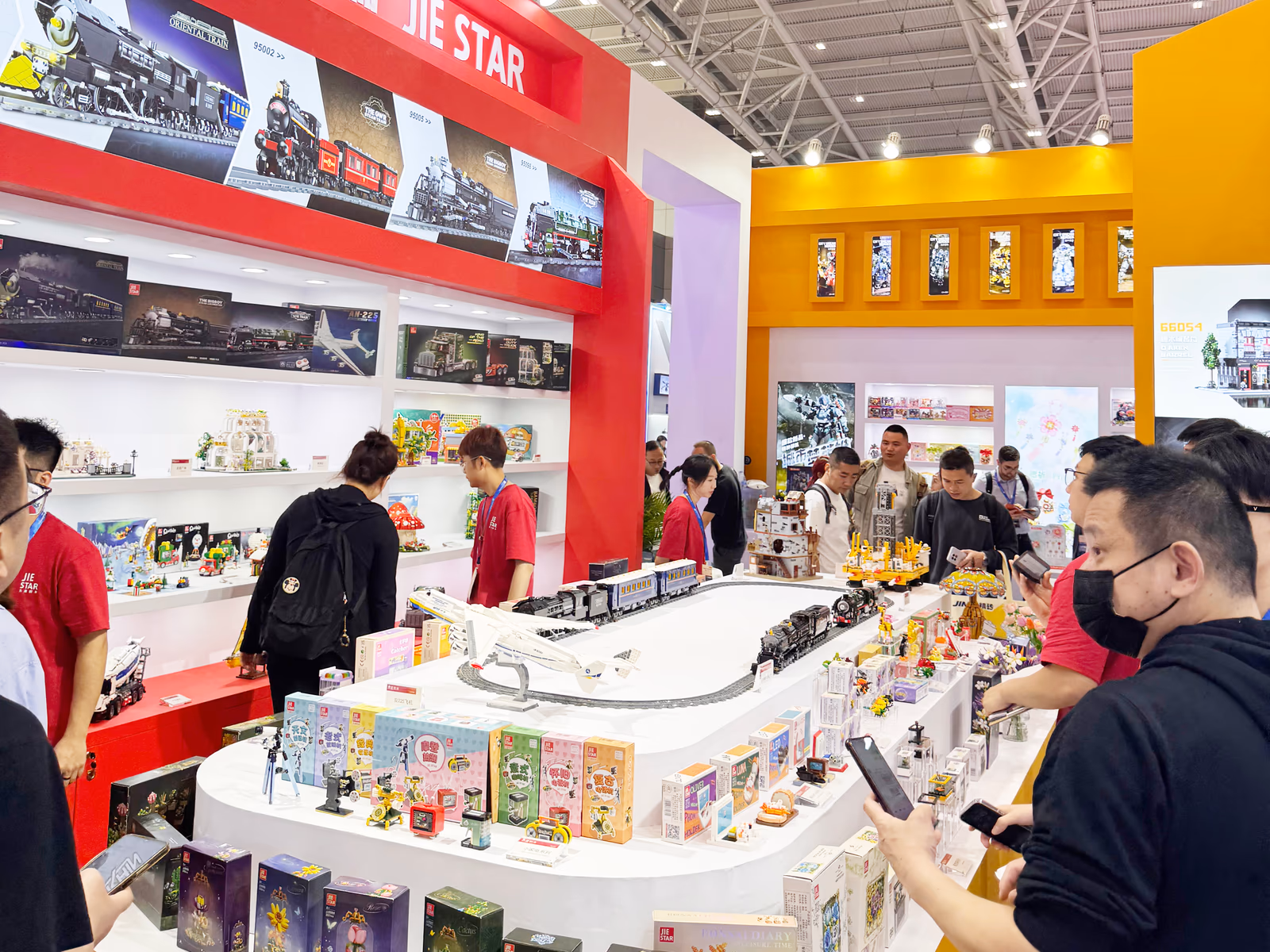 Visitors exploring trains, vehicles, and display models inside JIESTAR booth E7G32